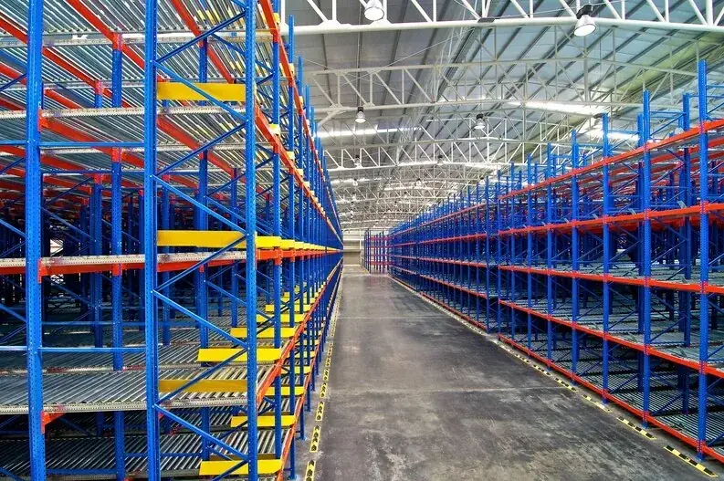 Long aisle of blue and orange pallet flow rack in a high-bay warehouse